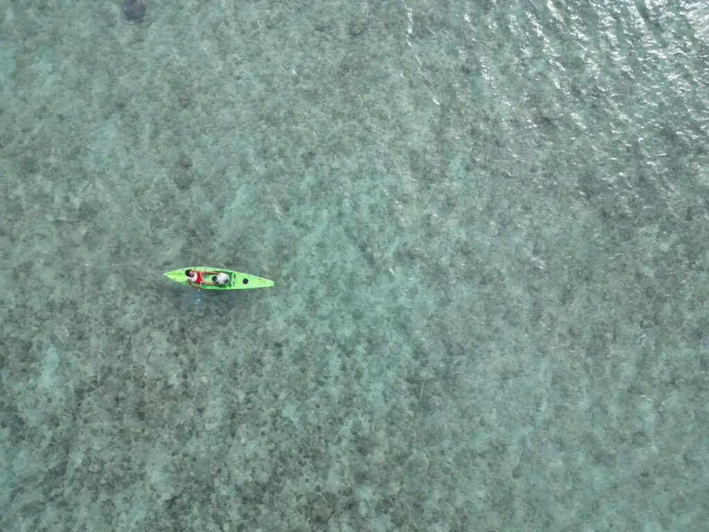 Aerial shot of a kayak in the clear ocean waters of West Nusa Tenggara, Indonesia.